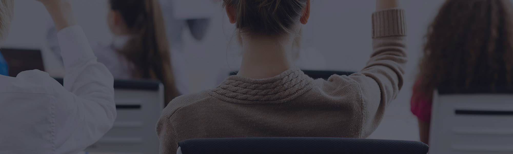 Students in Class with their Hands Raised